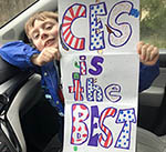 boy holding sign that says "CES is the best"